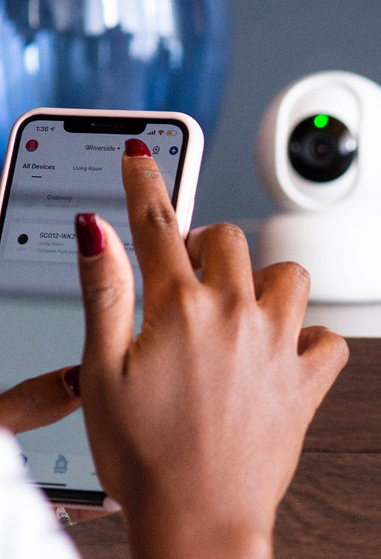 User using app in smartphone to configure camera.